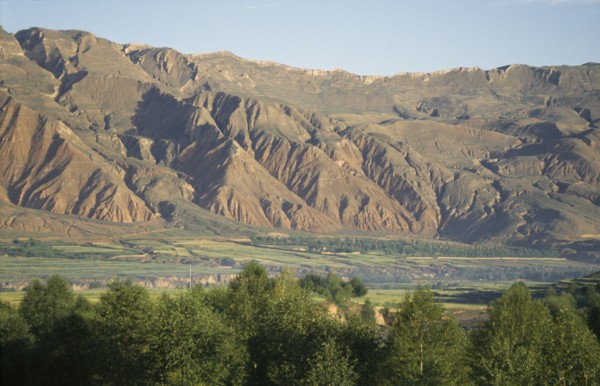 CHINA, Qinghai, General, Mountains behind trees and fields at the edge of the Tibetan plateau