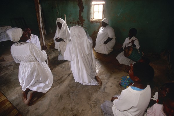 SOUTH AFRICA, KwaZulu Natal, Melmoth, Zulu Zionists women wearing white kneeling on the earth