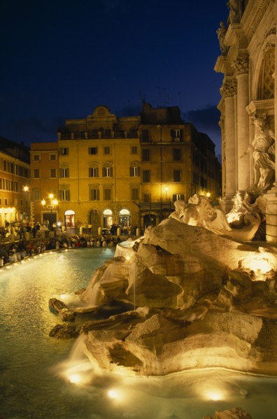 ITALY, Lazio , Rome, Trevi Fountain at night with people siting around the fountain