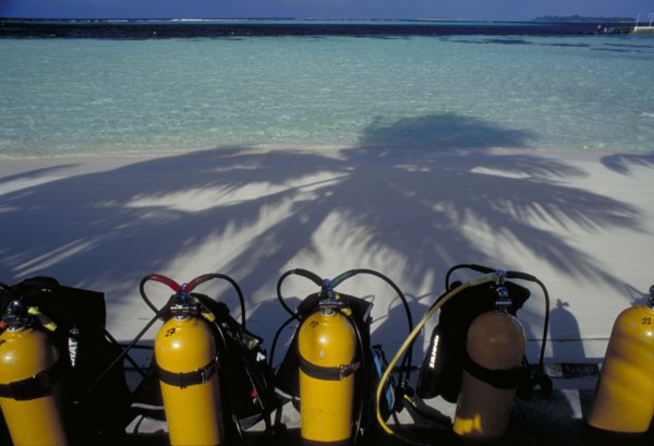 MALDIVES, Nika Island, Looking out to sea with scuba diving tanks on the beach in the shadow of