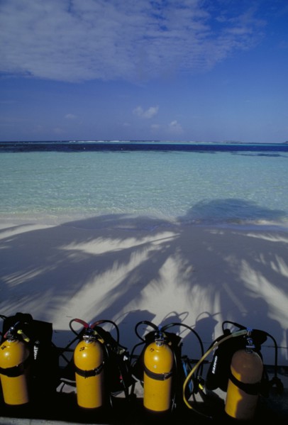 MALDIVES, Nika Island, View out to sea with scuba diving tanks on the beach in the shadow of