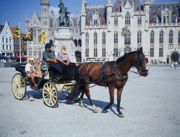 BELGIUM, West Flanders, Bruges, " A horse drawn tourist carriage in the Main Square, Grote Markt."