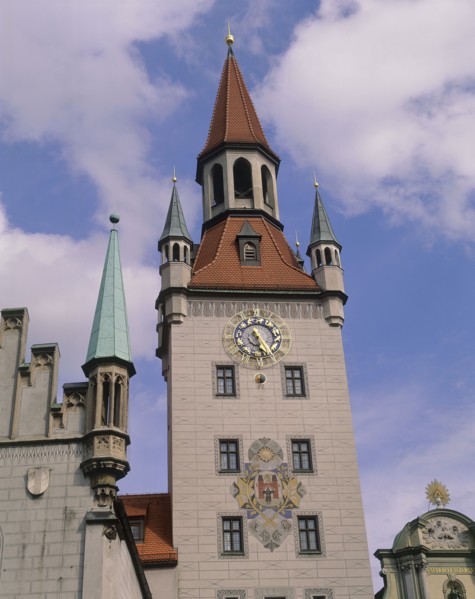 GERMANY, Bavaria, Munich, Clock tower with ornate clock and coat of arms with parts of the rooves