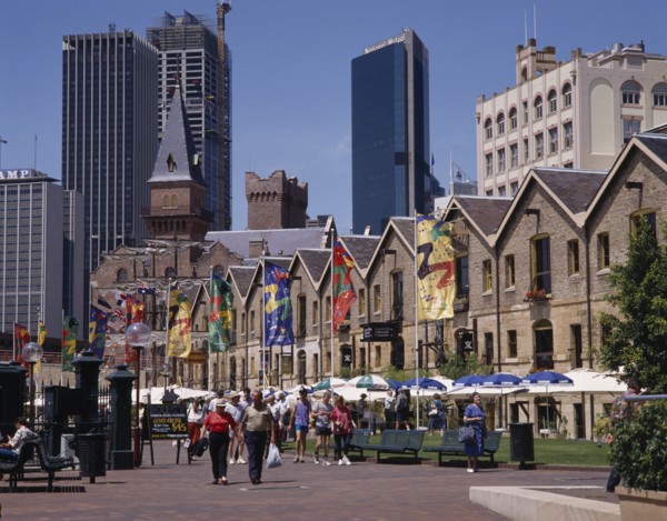 AUSTRALIA, New South Wales, Sydney, The Rocks harbourside area with people walking past restaurants