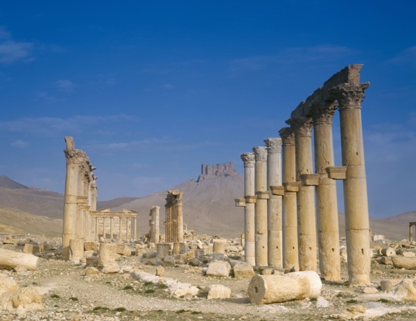 SYRIA, Central, Tadmur, "Monumental Arch, columns and fallen masonry with fort on hillside beyond.