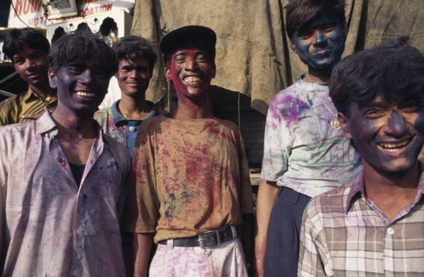 INDIA, Delhi , Group of young men with their faces covered with coloured powder paint dyes during