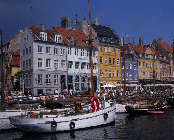 DENMARK, Zealand, Copenhagen, Nyhavn Harbour. Traditional waterfront buildings with crowds of