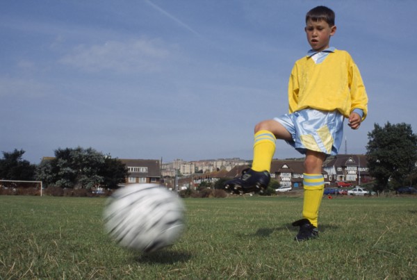 SPORT, Ball, Soccer, Young boy kicking football.