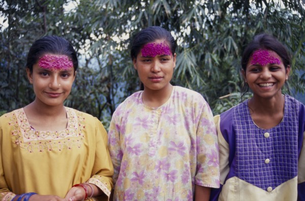INDIA, Sikkim , Tashiding, Three young women with coloured rice on their foreheads for Diwali.