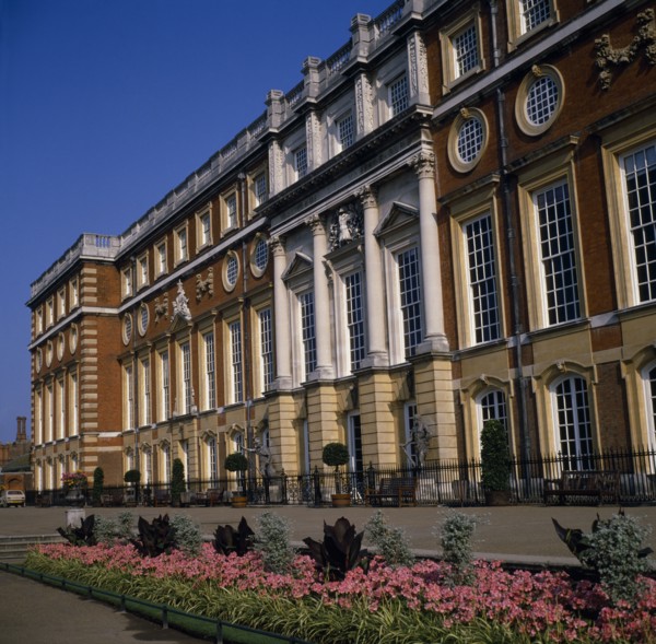 ENGLAND, London, Hampton Court Palace.  Angled view of exterior over     flower borders