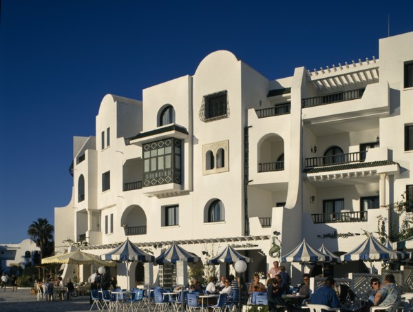 TUNISIA, Port El Kantaoui , Villas in an Arab style. Tourists sitting at tables outside cafe on