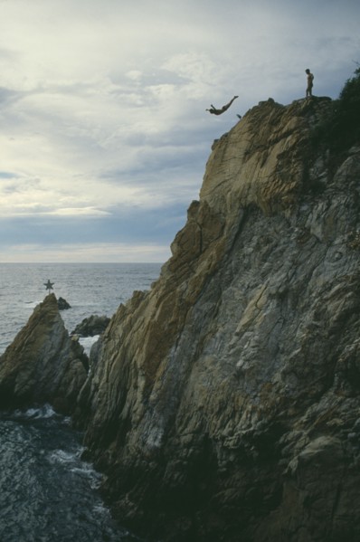 MEXICO, Guerrero, Acapulco, Cliff diver in mid air with sea below