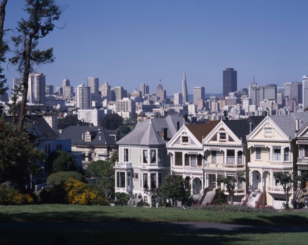 USA, California, San Fransisco, Alamo Square with city skyline beyond a row of timber town houses