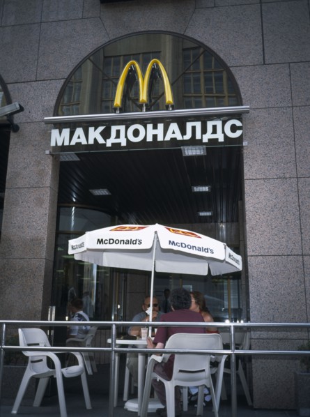RUSSIA, Moscow, McDonalds Restaurant with people sitting at table and chairs with umbrella outside