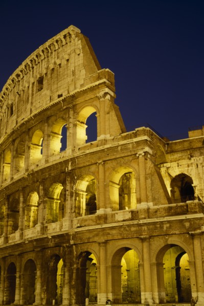 ITALY, LAZIO ,  ROME, The Colosseum exterior view at night of floodlit walls set against dark sky.