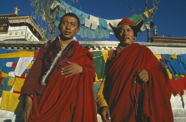 TIBET, Lhasa, Jokhang Temple, Two Buddhist monks in front of prayer flags