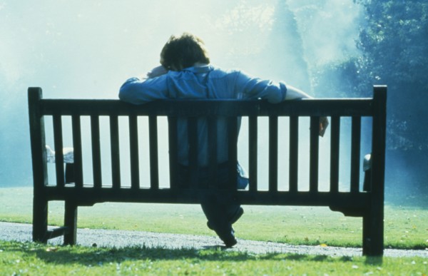 HEALTH, Emotional, Thoughtful single man sitting on park bench in slumped posture.