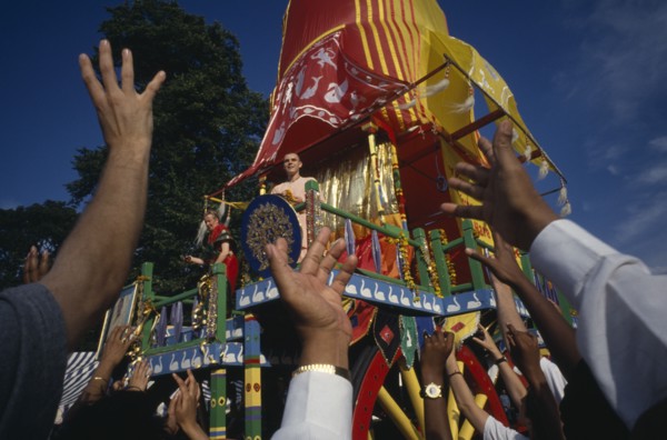 RELIGION, Hare Krishna, View over the reaching hands of a crowd toward brightly decorated cart with