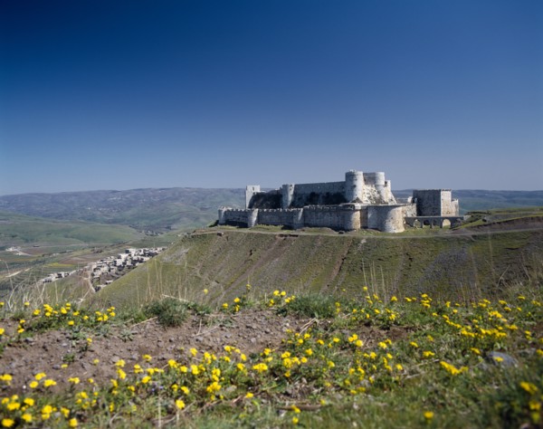 SYRIA, Central, Crac des Chevaliers, Crusader Castle in distance on plateau with village partly