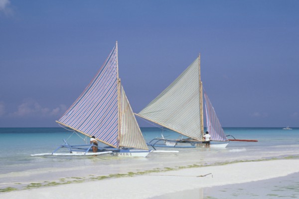 PHILIPPINES, Visayan Islands, Boracay Island, Two outriggers with striped sails moored on the edge