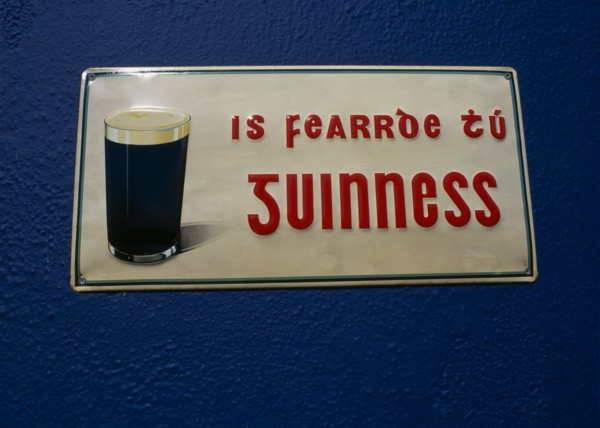 IRELAND, County Galway, Spiddal, Guinness sign written in Gaelic on Pub wall