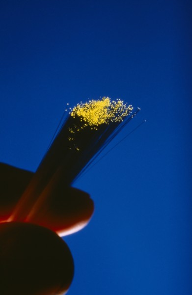 COMMUNICATIONS, Fibre Optics, Fibre optics cables with illuminated ends being held between a thumb