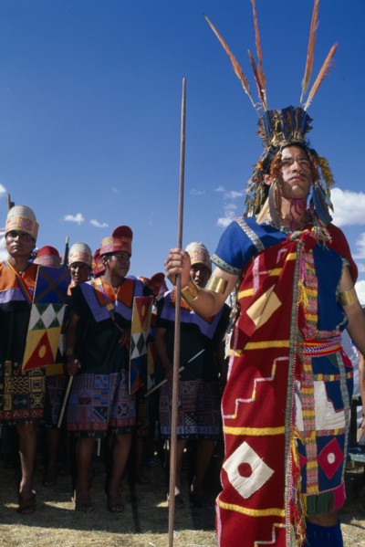 PERU, Cusco Department, Cusco, Male figure in traditional costume and feathered headress at Inti