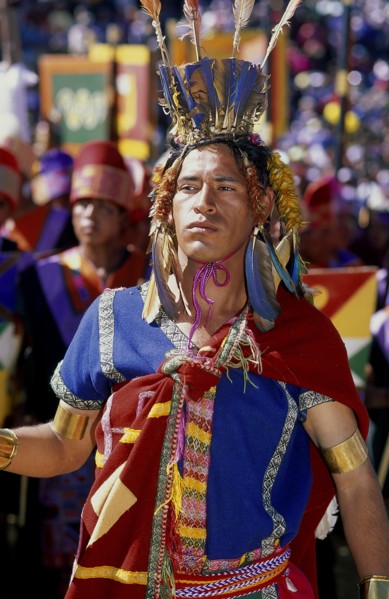PERU, Cusco Department, Cusco, Male figure in traditional costume and feathered headress at Inti