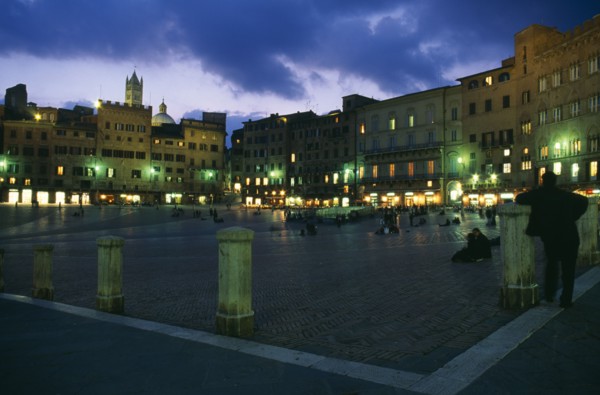 ITALY, Tuscany, Siena, Piazza del Campo.  Night view over Il Campo and cafes with people walking or