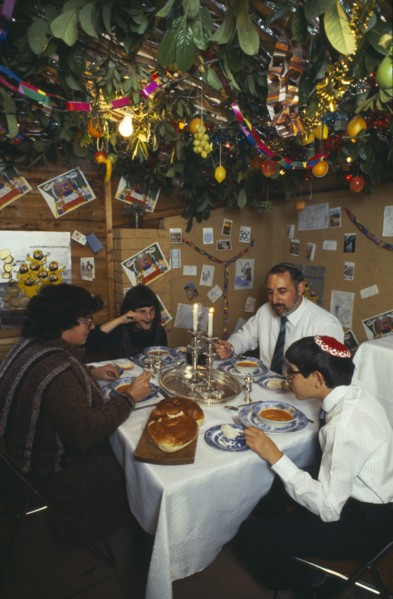 SOCIETY, Religion, Judaism, England.  Jewish family eating a meal in a Sukka during the Sukkot