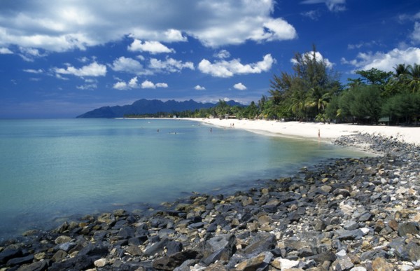 MALAYSIA, Langkawi, Kedah, Pantai Cenang beach looking towards Gunung Mat Cincang with a stoney