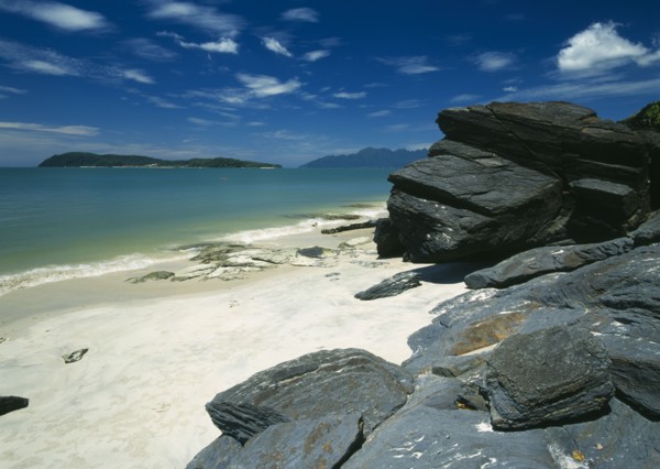MALAYSIA, Kedah, Langkawi, Pantai Tengah beach looking towards Pulau Rebak Besar island with rocks