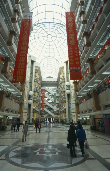 CHINA, Guangdong Province, Guangzhou, Multi level shopping centre interior with domed glass roof.