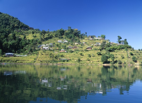 NEPAL, Annapurna Region, Pokhara, View over Lake Phewa with reflected terrace hillside and trees.
