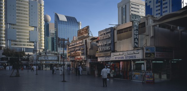 UAE, Abu Dhabi, The Old Souk. Exterior of jewellery and clothes shops with people walking through