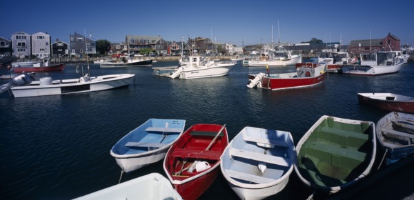 USA, Maine, Rockport, View over painted wooden rowing boats towards waterside buildings.