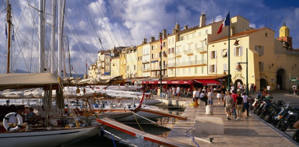 FRANCE, Provence-Cote d’Azur, St Tropez, "View along busy waterfront  with boats moored at the