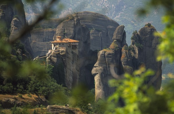 GREECE, Thessalia, Meteora, "Monastery  amongst eroded rock pinnacles, seen through tree branches.