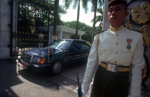 MALAYSIA, Kuala Lumpur, The Kings Palace.  Guard in uniform outside palace gates with official car