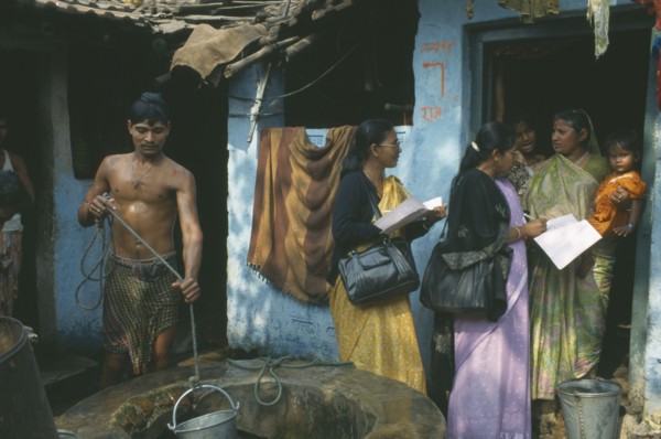 INDIA, Tamil Nadu, Madras, Women conducting a survey on reproductive health talk to a woman holding