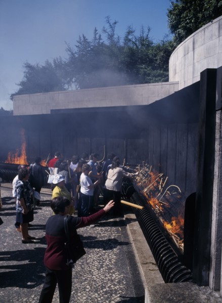 PORTUGAL, Biera Litoral, Fatima, Pilgrims throwing candle offerings into fire