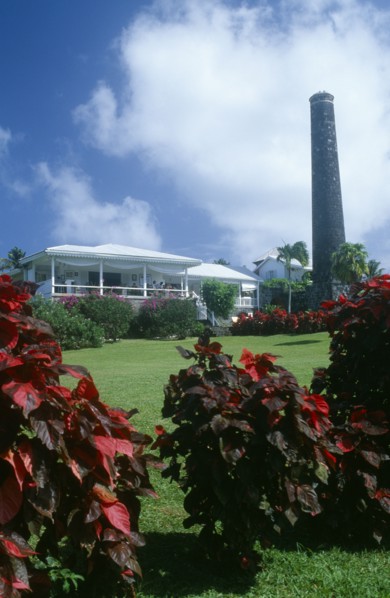 WEST INDIES, St Kitts, Rawlins Plantation Inn, Exterior with people on white painted balcony and