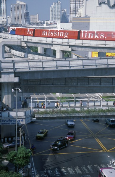 THAILAND, Bangkok, Sky Train above pedestrian walkways and road traffic at the junction of Rama 1