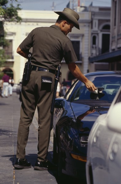 WEST INDIES, Puerto Rico, San Juan, Traffic policeman issuing parking ticket.