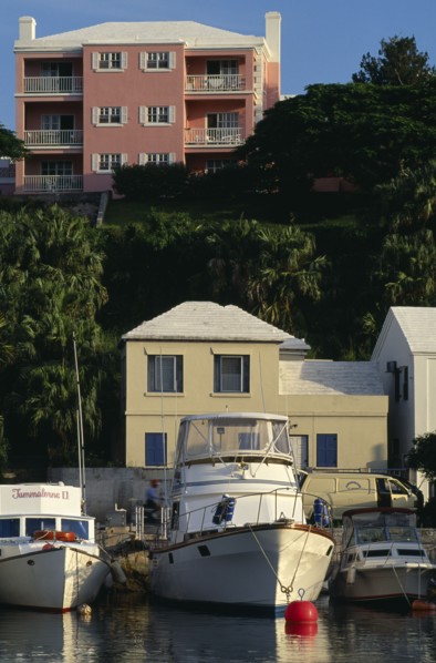 BERMUDA, Flatts Village, Pink building with white shutters and balconies overlooking boats moored