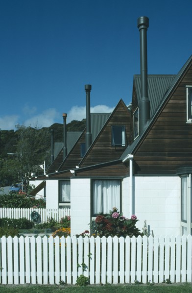 NEW ZEALAND, South Island, Akaroa, Line of houses with narrow chimneys and white painted picket