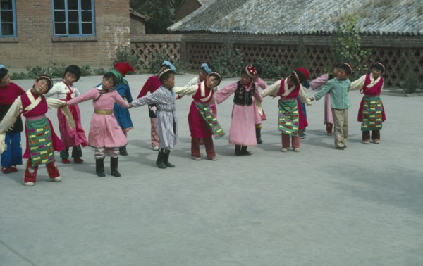 CHINA, Hebei Province, Chengde, Line of children at kindergarten with linked arms and heads