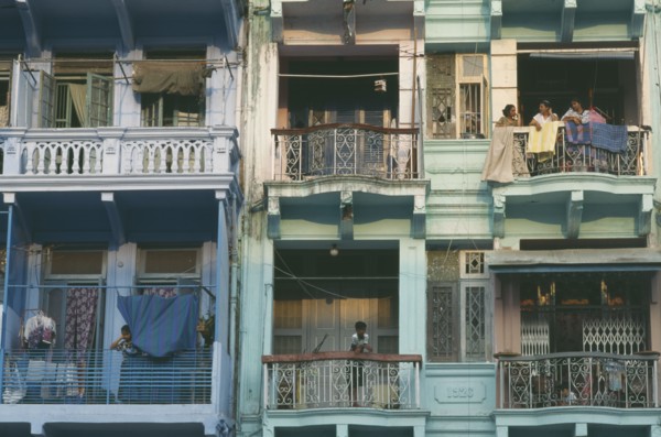 MYANMAR, Yangon, Building detail of balconies with hanging washing and people standing