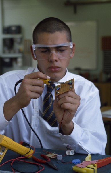 EDUCATION, Secondary School, Science, Schoolboy in electronics class wearing protective glasses