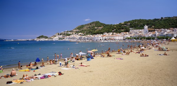 SPAIN, Catalonia, El Port de La Selva, "Curved, sandy beach with people sunbathing and in the water